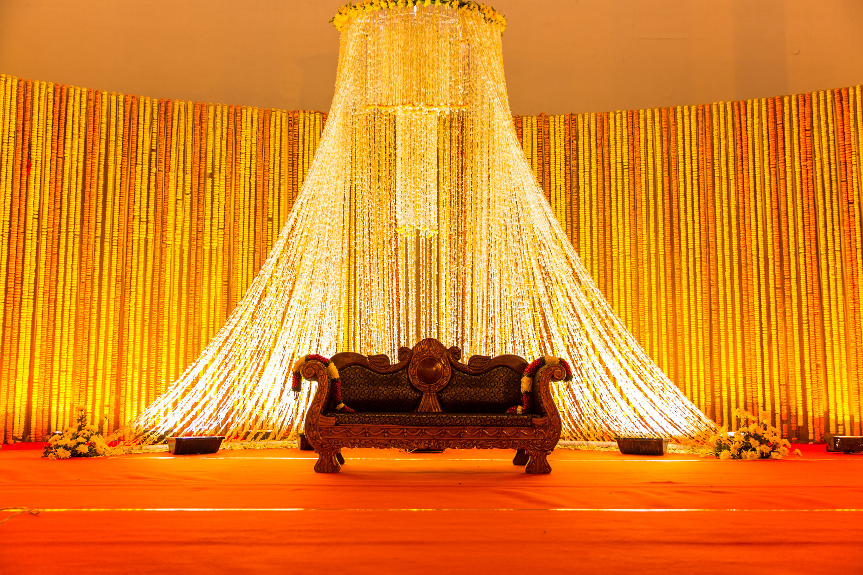 Indian wedding stage decorations with colorful flowers.
